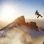 Epic Adventurous Extreme Sport Composite of Rock Climbing Man Rappelling from a Cliff