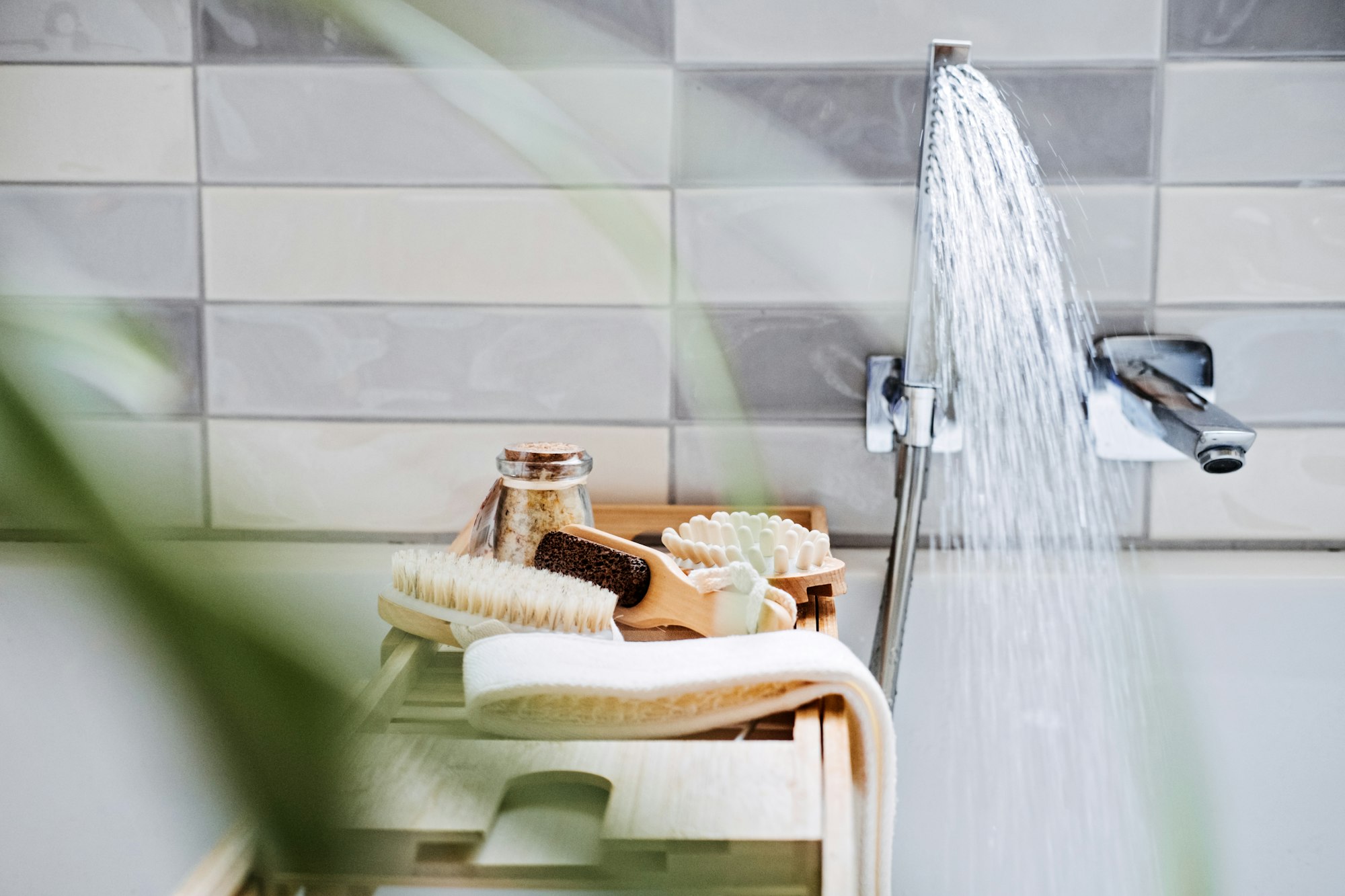 Wooden tray with home spa supplies and bathrobe in modern home bathroom for relaxing rituals. Spa