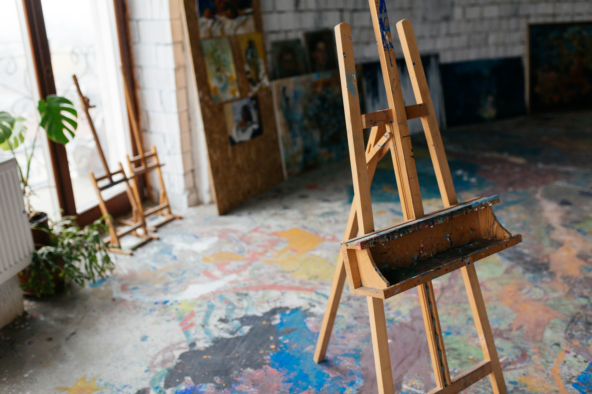 Close up photo of classic wood easel in modern art workshop with